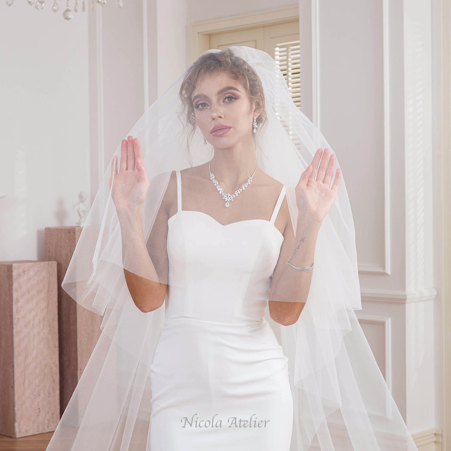 Bride lifting the double layer blusher of a soft tulle wedding veil Nicola Xu Atelier.