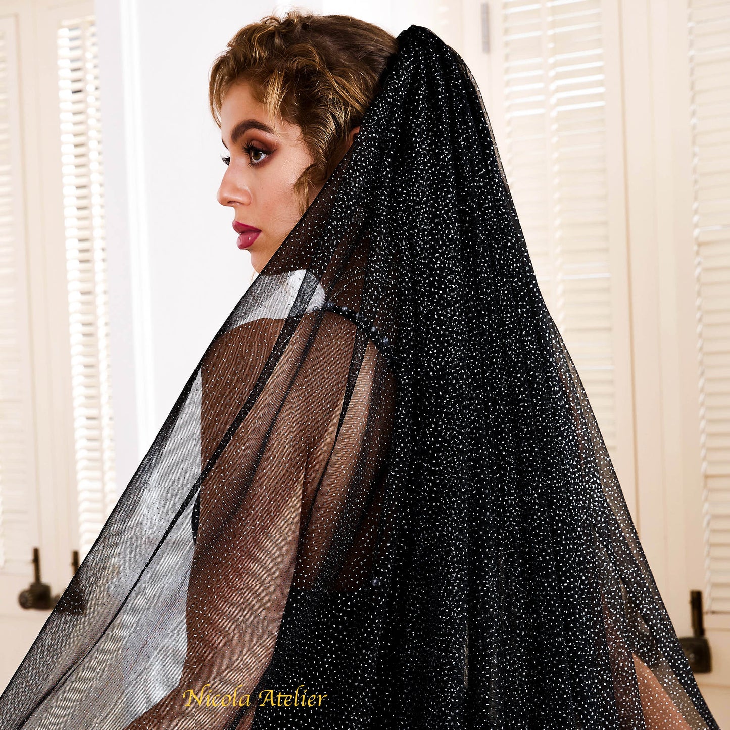 Side profile of a bride wearing a black raw-edge tulle veil with catching silver light by Nicola Xu Atelier.