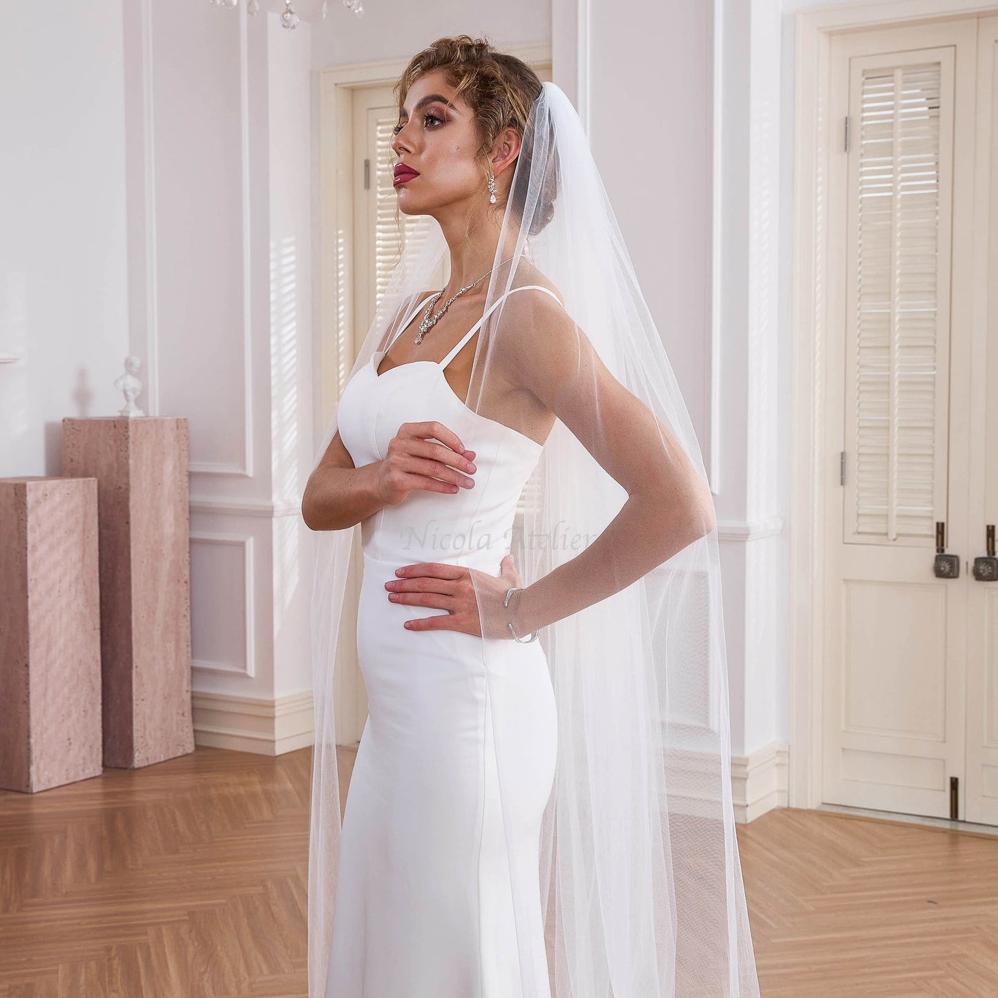 Profile of bride wearing soft white cathedral veil, elegant "quiet luxury" bridal style,